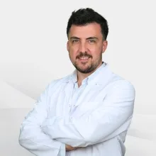 Dr. Öğr. Üyesi Hüsnü Hacı — Plastik Rekonstrüktif Ve Estetik Cerrahi, Karşıyaka, İzmir. Portre fotoğrafı.